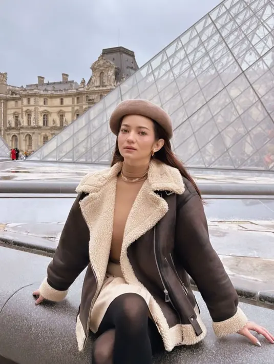 Gaya Enzy ala perempuan Prancis lainnya dengan biker jacket, tight, dan topi beret. [@enzystoria]