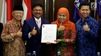 Balon Gubernur dan Wagub Jawa Timur, Khofifah Indar Parawansa (kedua kanan) dan Emil Dardak (kanan) menunjukkan Surat Persetujuan Pasangan Cagub dan Cawagub dari DPP Partai Nasdem di Kantor Partai Nasdem, Jakarta, Selasa (2/1). (Liputan6.com/Johan Tallo)