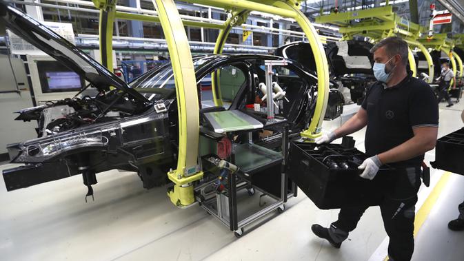 Pekerja merakit mobil Mercedes-Benz S-class di pabrik Mercedes, Sindelfingen, Jerman, Kamis (30/4/2020). Mulai 27 April 2020, Mercedes-Benz kembali membuka jalur produksi yang sebelumnya ditutup karena pandemi virus corona COVID-19. (AP Photo/Matthias Schrader)