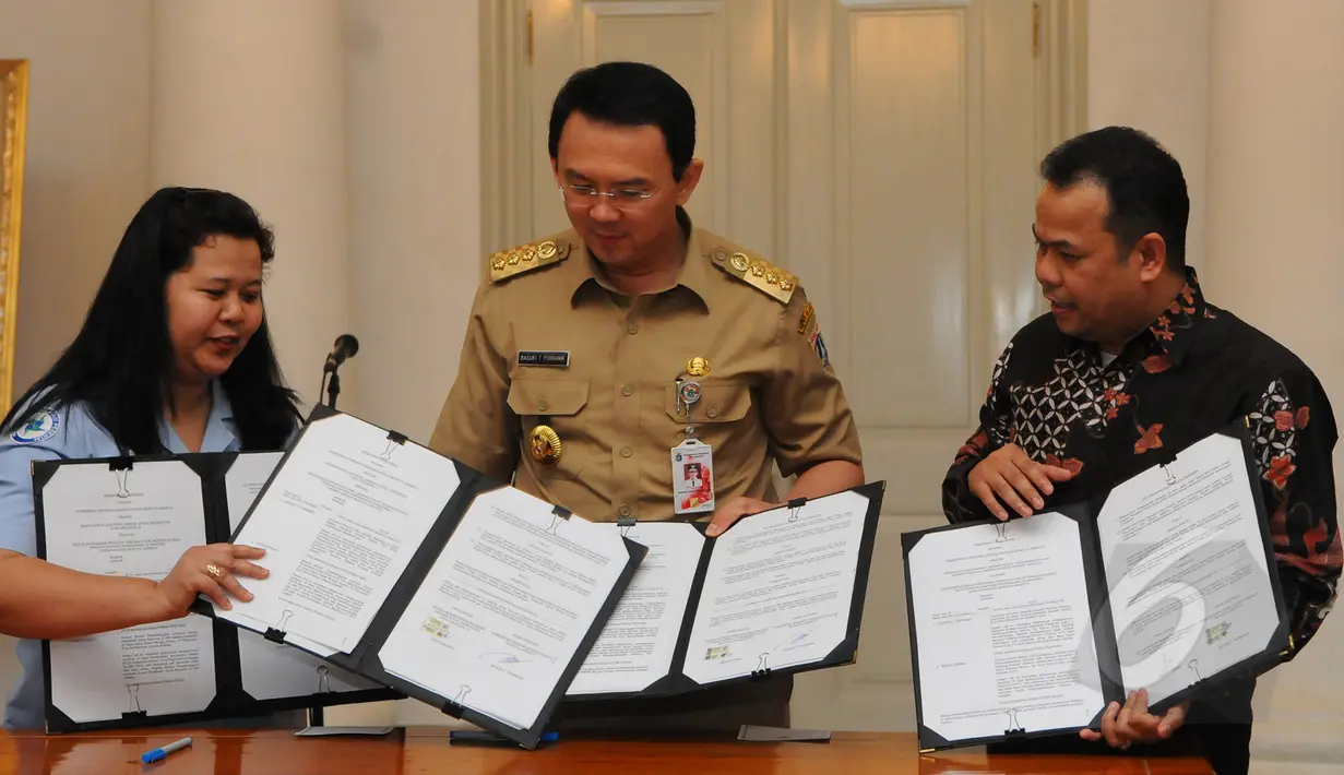 Gubernur DKI Jakarta Basuki T Purnama memperlihatkan nota kesepahaman (MoU) yang telah ditandatangi dengan pihak BPJS di Balaikota, Jakarta, Rabu (1/4/2015).  (Liputan6.com/Herman Zakharia)