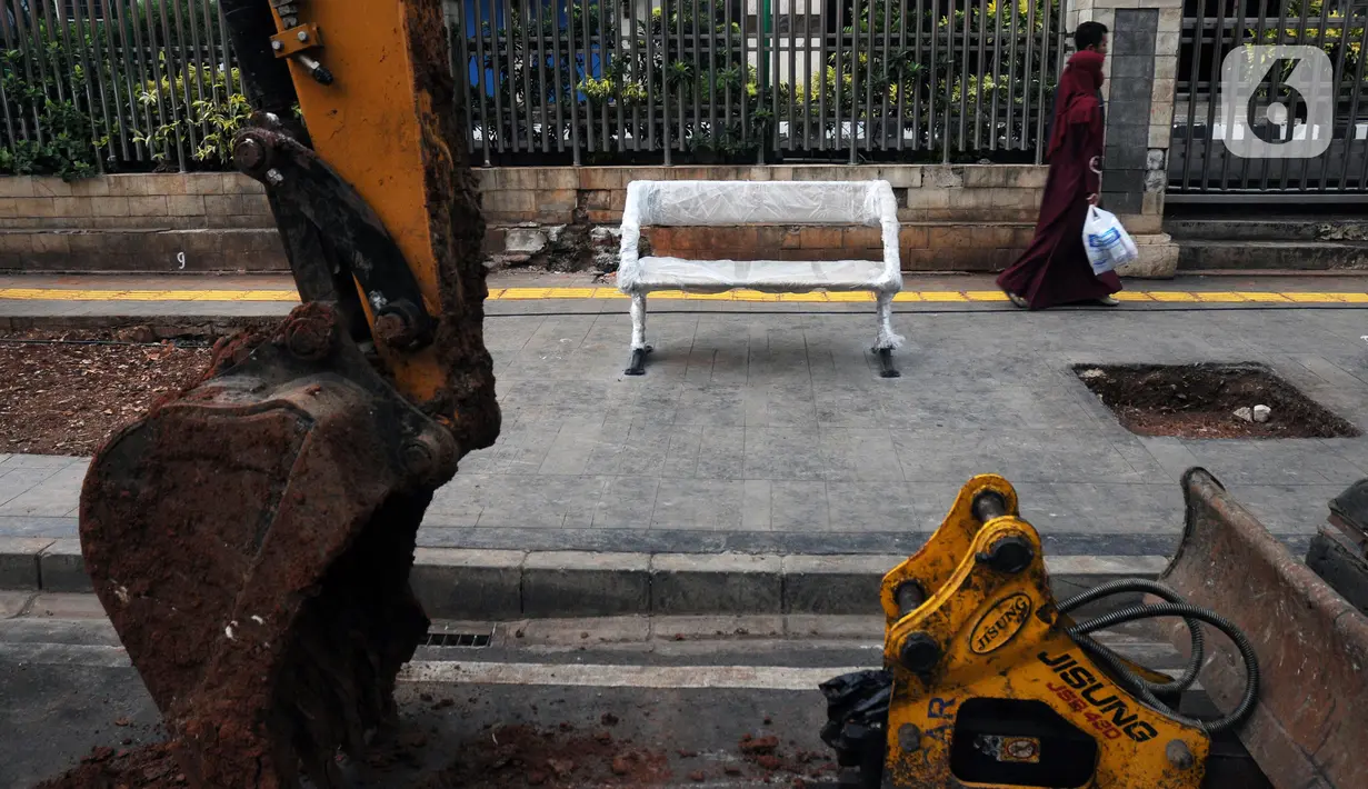 Warga melintas di trotoar di kawasan Jalan Cikini Raya, Jakarta, Minggu (8/12/2019). Sebagai bagian dari proyek revitalisasi, kini sepanjang trotoar Cikini Raya mulai terpasang bangku-bangku taman. (Liputan6.com/Helmi Fithriansyah)