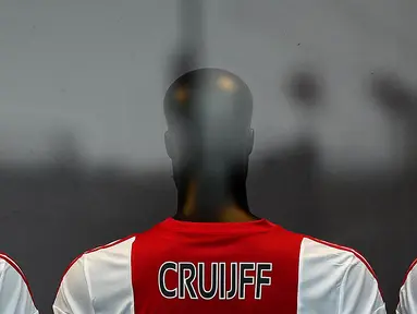 Toko Ajax Fanshop memasang jersey bernama Cruyff yang berada di sekitar Stadion Amsterdam Arena, Amsterdam, Kamis (24/3/2016). Legenda sepak bola dunia, Johan Cruyff, meninggal dunia pada Kamis (24/3/2016) karena sakit kanker. (AFP/Franck Fife)