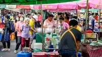 Orang-orang berbelanja di pasar terbuka di luar Taman Lumpini yang dibuka kembali setelah pelonggaran beberapa langkah pengendalian karena Corona COVID-19 di Bangkok, Minggu (3/5/2020). Thailand mulai melonggarkan aturan pembatasan pergerakan orang dan pertemuan. (Mladen ANTONOV/AFP)