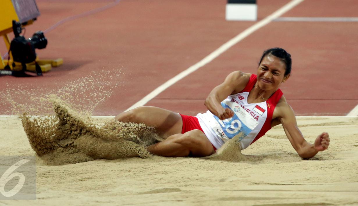 Atlet putri Indonesia, Maria Londa saat mendarat usai melakukan lompatan di nomor lompat jangkit di National Stadium, Singapura, Kamis (11/6/2015). Maria mencatat lompatan sejauh 13,75 meter dan berhasil meraih emas. (Liputan6.com/Helmi Fithriansyah)