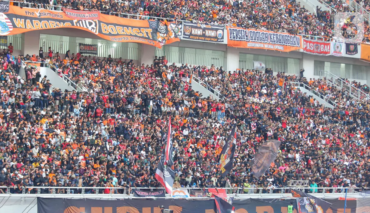 Suporter bernyanyi dan meneriakan yel-yel saat peresmian Stadion Jakarta International Stadium (JIS) di Jakarta, Minggu (24/7/2022). Sederet artis papan atas Ibu Kota turut meramaikan acara tersebut antara lain Dewa 19 dan Virzha, Kotak Band serta Setia Band. Selain itu, panitia juga akan menggelar pertandingan persahabatan sepakbola. (Liputan6.com/Herman Zakharia)