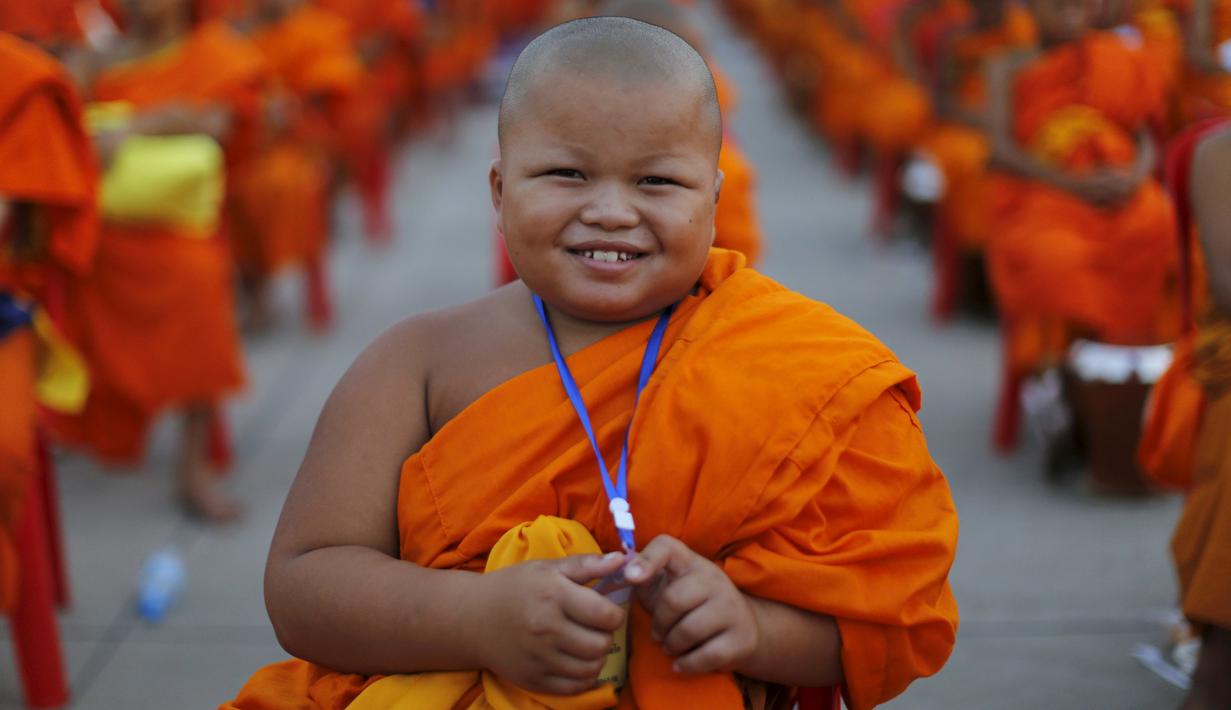 Seorang Biksu Buddha tersenyum saat menunggu acara penerimaan sedekah di kuil Wat Phra Dhammakaya, Bangkok, Thailand, (22/4). Kegiatan ini juga sebagai penasbihan para bhikkhu dan samanera atau calon Biksu. (REUTERS / Jorge Silva)