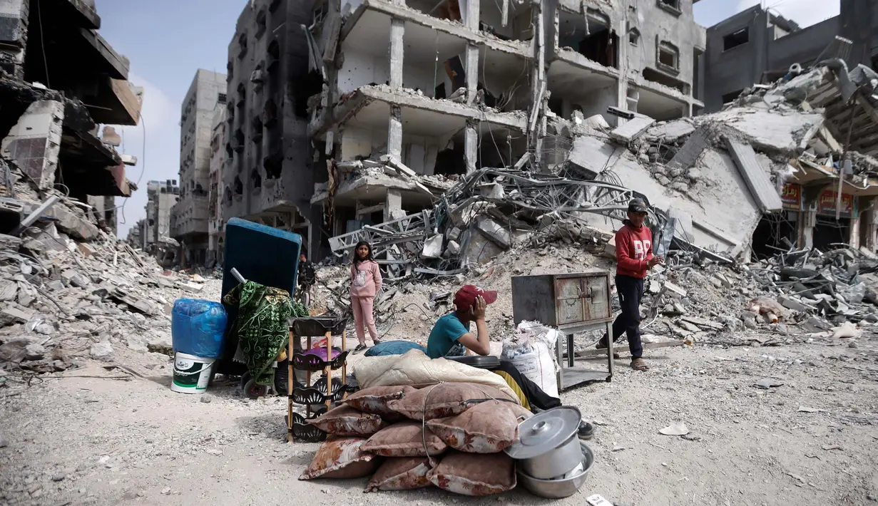Warga Palestina duduk di dekat barang-barang mereka setelah mengunjungi rumah mereka yang hancur dalam serangan Israel di Khan Younis, Jalur Gaza, Rabu, 6 Maret 2024. (AP Photo/Mohammed Dahman)