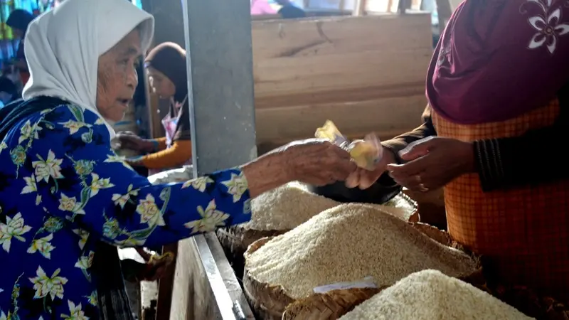 Seorang nenek membayar beras di pasar tradisional Cilacap, Jawa Tengah. (Foto: Liputan6.com/Muhamad Ridlo)