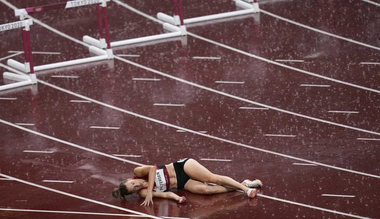 Sara Petersen dari Denmark terbaring di lintasan setelah terjatuh pada semifinal lari gawang 400 meter putri Olimpiade Tokyo 2020 di Tokyo, Jepang, Senin (2/8/2021). (AP Photo/Francisco Seco)