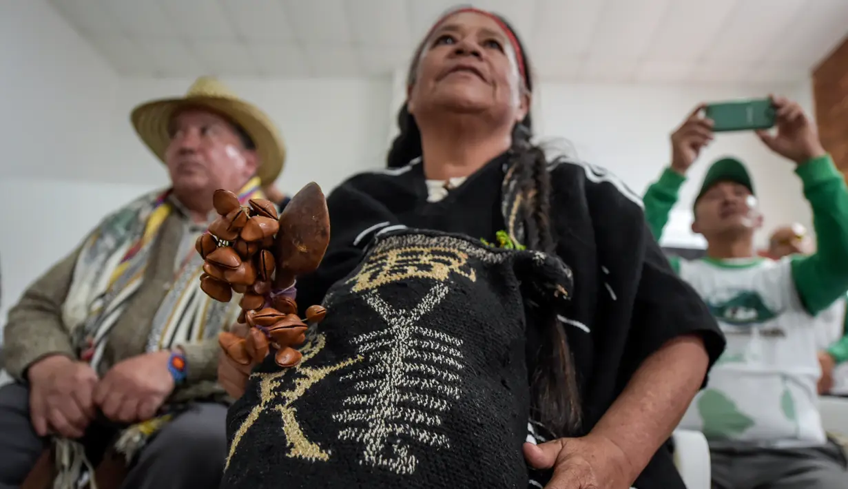 Penduduk asli Kolombia mengenakan pakaian adat berkumpul untuk merayakan Hari Internasional Penduduk Asli / Masyarakat Adat di Bogota (9/8). (AFP Photo/Raul Arboleda)