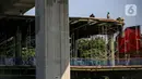 Aktivitas pekerja di area proyek pembangunan skybridge di simpang CSW, Jakarta Selatan, Senin (27/7/2020). Proyek yang akan mengintegrasikan Halte Transjakarta Koridor 1 (Blok M-Kota) dan Koridor (Ciledug-Mampang) dengan Stasiun MRT Asean ditargetkan rampung akhir 2020. (Liputan6.com/Faizal Fanani)