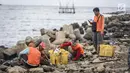 Petugas kebersihan membersihkan sampah laut di Pelabuhan Kali Adem, Jakarta, Senin (1/1). Banyaknya sampah plastik dibandingkan ikan yang gagal dikelola dengan baik membuat limbah yang mengakibatkan laut tercemar.  (Liputan6.com/Faizal Fanani)