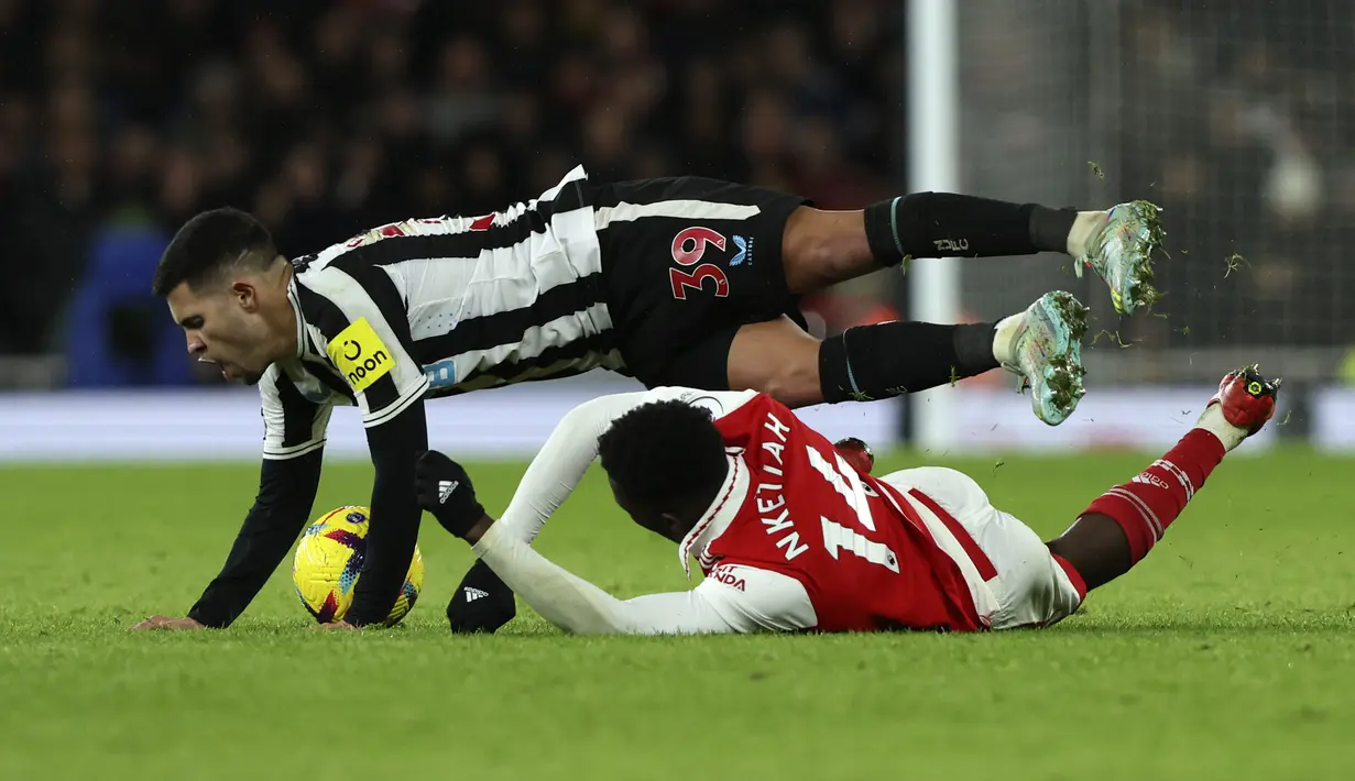 Penyerang Arsenal, Eddie Nketiah berebut bola dengan gelandang Newcastle United, Bruno Guimaraes selama pertandingan lanjutan Liga Inggris di stadion Emirates di London, Rabu (4/1/2023). Arsenal bermain imbang atas Newcastle dengan skor 0-0. (AP Photo/Ian Walton)