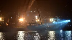 Sebuah crane mengevakuasi bus setelah jatuh dari jembatan ke Sungai Yangtze di Chongqing barat daya China (1/11). Menurut laporan, kecelakaan tersebut menewaskan sedikitnya sembilan orang. (AFP Photo/Str)