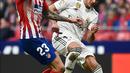 Gelandang Real Madrid,  Lucas Vazquez berebut bola dengan striker Atletico Madrid, Vitolo selama pertandingan lanjutan La Liga Spanyol di stadion Wanda Metropolitano (9/2). Real Madrid menang 3-1 atas Atletico. (AFP Photo/Pierre-Philippe Marcou)