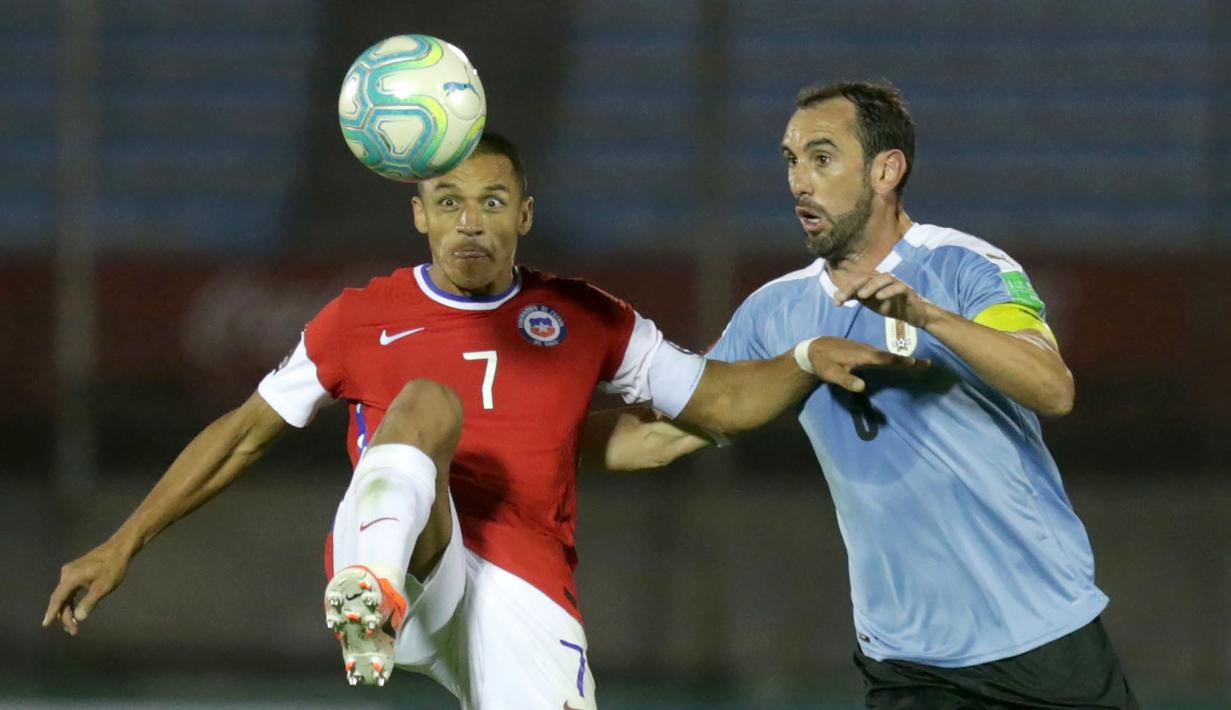 Bek Uruguay, Diego Godin, berebut bola dengan penyerang Chile, Alexis Sanchez, pada laga kualifikasi Piala Dunia 2020 zona Amerika Selatan di Estadio Centenario, Jumat (9/10/2020) pagi WIB. Uruguay menang 2-1 atas Chile. (AFP/Matilde Campodonico/pool)