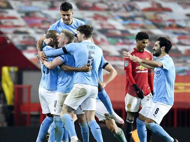 Para pemain Manchester City merayakan gol yang dicetak oleh Fernandinho ke gawang Manchester United pada laga Piala Liga Inggris di Stadion Old Trafford, Rabu (6/1/2021). City menang dengan skor 2-0. (Peter Powell/Pool via AP)