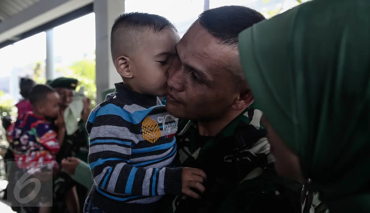 Seorang bocah mencium seorang personel TNI-AD di Pelabuhan Kolinlamil, Jakarta, Senin (9/5). Sebanyak 450 personel TNI-AD dari Satgas Yonif Para Raider 330 inf 1 Kostrad dilepas untuk misi pengamanan perbatasan RI-PNG. (Liputan6.com/Faizal Fanani)