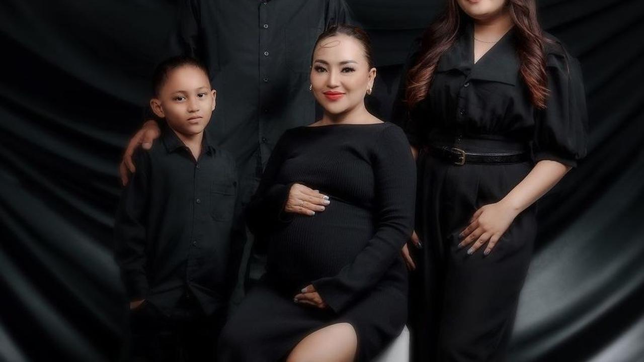 Salah satu maternity shoot yang dilakukan Mpok Alpa adalah foto keluarga dengan perut hamil, yang terlihat glamor dengan nuansa hitam.<br>