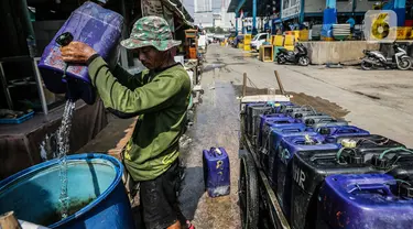 Penjual memenuhi drum atau wadah penyimpanan milik pembeli dengan air bersih yang dijualnya di Kawasan Muara Angke, Jakarta Utara, Rabu (30/8/2023). (Liputan6.com/Faizal Fanani)