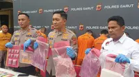 Kapolres Garut AKBP Rio Wahyu Anggoro, menunjukan beberapa barang bukti tembakau sintetis dalam rilis kasus di Mapolres Garut, Senin (10/4/2023). (Liputan6.com/Jayadi Supriadin)