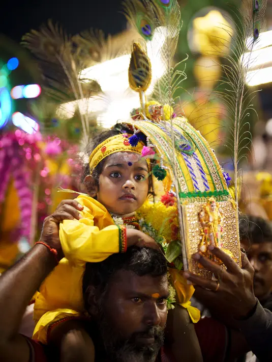 Umat Hindu membawa kanopi berhias yang disebut "kavadi" dan anak-anak berjalan menuju Kuil Swamy Sri Subramaniar pada perayaan Thaipusam di Batu Caves, Kuala Lumpur, Malaysia, Minggu (5/2/2023). Thaipusam, yang dirayakan untuk menghormati Dewa Murugan, adalah acara tahunan umat Hindu untuk mencari berkah, memenuhi sumpah, dan mengucapkan terima kasih. (AP Photo/Vincent Thian)