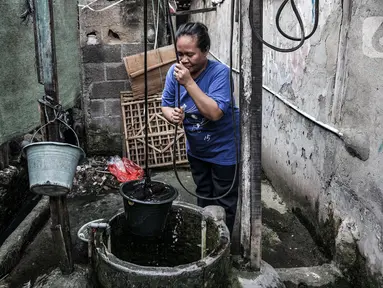 Warga menggunakan sumur timba untuk keperluan mandi, cuci, dan kakus (MCK) di kawasan Sukapura, Cilincing, Jakarta, Senin (22/3/2021). Sumur timba masih menjadi sumber air utama bagi sebagian warga di RW 005 Kelurahan Sukapura. (merdeka.com/Iqbal S. Nugroho)