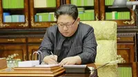 Gambar video yang disiarkan oleh KRT Korea Utara pada 29 November 2017, menunjukkan pemimpin Korea Utara Kim Jong Un menandatangani sebuah dokumen izin uji coba rudal pada 28 November 2017. (KRT via AP Video)