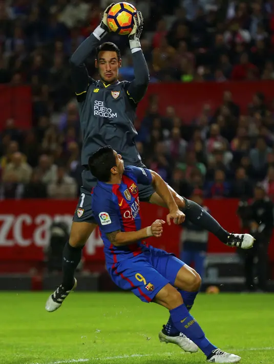 Penyerang Barcelona, Luis Suarez  berusaha merebut bola dari kiper Sevilla, Sergio Rico pada lanjutan La Liga spanyol di Stadion Sanchez Pizjuan,  Spanyol, (7/11). Barcelona menang atas Sevilla 2-1. (REUTERS/ Marcelo del Pozo)