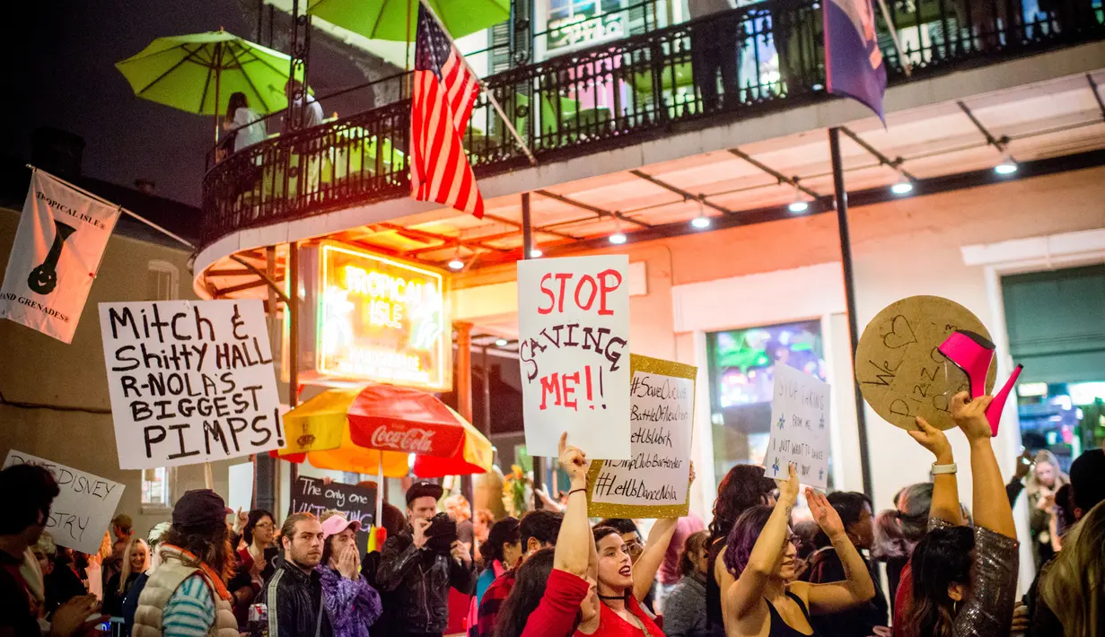Sejumlah orang membawa poster saat melakukan demonstrasi di Bourbon Street, New Orleans (1/2). Mereka melakukan aksi terkait penggerebekan polisi dan penutupan sejumlah klub malam di Bourbon Street. (AFP/Emily Kask)