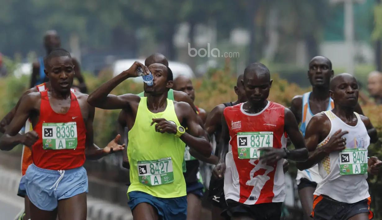 Peserta minum saat lomba lari Milo Jakarta International 2017 di kawasan Kuningan, Jakarta, Minggu (23/7/2017). Ajang lomba lari tersebut diikuti 15.000 peserta dengan kategori 5K, 10K dan Family Run 1,7K. (Bola.com/M Iqbal Ichsan)