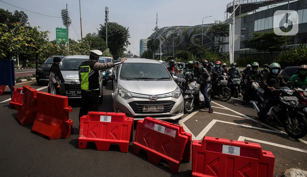 Aparat kepolisian mengarahkan kendaraan saat penyekatan di Jalan Pemuda, Jakarta Selatan, Kamis (15/7/2021). PPKM darurat, Polda Metro Jaya menambahkan penyekatan 100 titik di Jakarta dan sekitarnya pada hari ini hingga mengakibatkan kemacetan parah di ruas tersebut. (Liputan6.com/Johan Tallo)