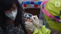 Petugas medis menyuntikan vaksin Covid-19 ke dokter di Puskesmas Cengkareng, Jakarta Barat, Selasa (9/2/2021). Kementerian Kesehatan memulai vaksinasi Sinovac untuk tenaga kesehatan di atas 60 tahun setelah BPOM mengeluarkan izin penggunaan vaksin untuk lansia. (Liputan6.com/Fery Pradolo)