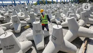 Pekerja menyelesaikan proses pembuatan tetrapod untuk pengaman Pantai Singapura di Plant Karawang PT Waskita Beton Precast, Jawa Barat, Rabu (17/6/2020). Era new normal, produksi beton cetak dan pra cetak terus berjalan dengan menerapkan protokol kesehatan. (Liputan6.com/Fery Pradolo)