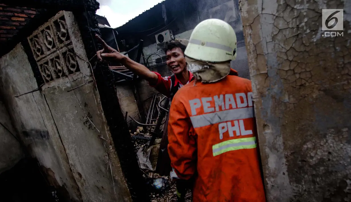 Petugas pemadam kebakaran saat berusaha memadamkan sisa-sisa kebakaran gudang kosmetik di Jalan Bandengan 1 No 56, RT 04/12, Kelurahan Pekojan, Kecamatan Tambora, Jakarta Barat, Senin (4/12). (Liputan6.com/Faizal Fanani)