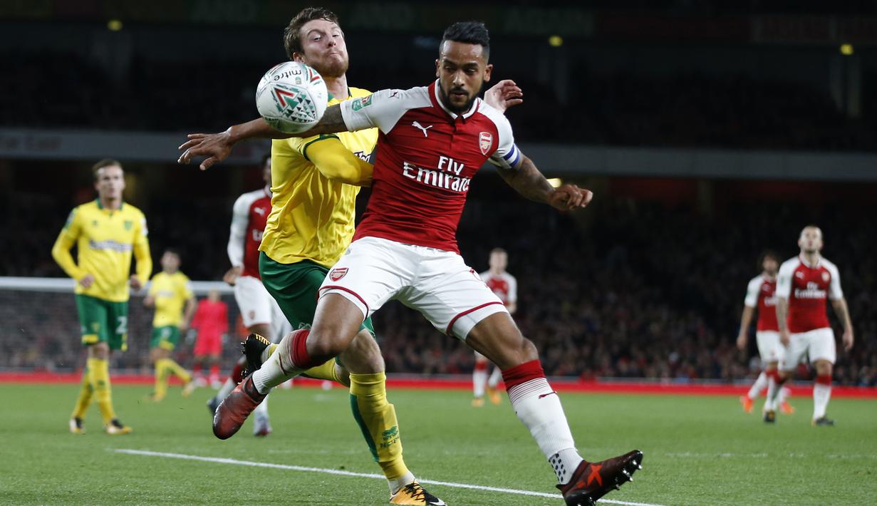 Pemain Arsenal, Theo Walcott (kanan) mencoba melewati adangan pemain Norwich City, James Husband pada laga Piala Liga Inggris di Emirates Stadium, London, (24/10/2017). Arsenal menang 2-1. (AP/Alastair Grant)
