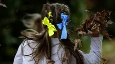 Anak-anak dengan pita warna nasional Ukraina di rambut mereka bermain di perayaan hari Kemerdekaan Ukraina di sebuah perayaan di Chichester, Inggris selatan, Sabtu, 27 Agustus 2022. Chichester dinobatkan sebagai daerah paling dermawan di negara itu untuk menampung pengungsi Ukraina. (AP Photo/Frank Augstein)