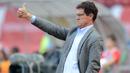 Fabio Capello pernah membuat aturan tak lazim untuk pemainnya saat melatih Timnas Inggris. Ia melarang pemainnya menggunakan sendal jepit, bermain game konsol, dan celana pendek dihadapan publik dengan alasan agar terlihat lebih professional. (Foto: AFP/Natalia Kolesnikova)