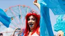 Peserta mengenakan busana seperti putri duyung sambil berenang di pantai saat mengikuti parade Mermaid, Brooklyn , New York , (18/6). Parade ini diikuti lebih dari 3000 orang peserta yang mengenakan busana bertema Mermaid. (REUTERS / Eduardo Munoz)