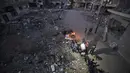 Warga Palestina berkumpul dekat reruntuhan bangunan yang hancur selama konflik antara Hamas dan Israel pada Mei 2021 di Beit Hanun, Jalur Gaza, Senin (7/6/2021). Hamas dan Israel gencatan senjata setelah perang selama 11 hari. (MAHMUD HAMS/AFP)