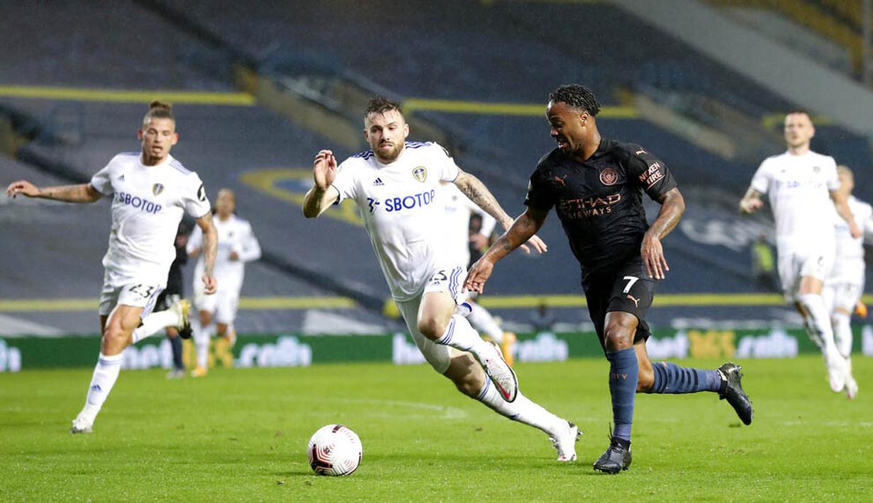 Penyerang Manchester City, Raheem Sterling, berusaha melewati pemain Leeds United pada laga Liga Inggris di Stadion Elland Road, Sabtu (3/10/2020). Kedua tim bermain imbang 1-1. (Cath Ivill/Pool via AP)