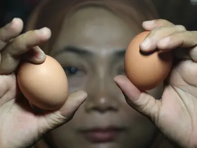 Pedagang menunjukkan telur ayam di pasar tradisional di Jakarta, Kamis (6/12). Harga telur ayam ras di pasar tradisional di DKI Jakarta mengalami tren kenaikan sejak bulan lalu. (Liputan6.com/Immanuel Antonius)