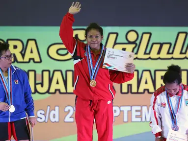 Lifter Bali, Sinta Luh Darmariani (tengah) diapit Dwi M Lestari (Jabar) dan Naomi L Rumbewas (Papua Barat) di podium kemenangan angkat besi putri kelas 63kg di Gymnasium Si Jalak Harupat, Kab Bandung, Rabu (21/9). (Liputan6.com/Helmi Fithriansyah)