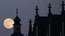 Bulan purnama tampak di belakang gereja Deutschorden dan atap gereja Dreikönig di Frankfurt am Main, Jerman barat, (10/5). (AFP Photo/dpa/Frank Rumpenhorst/Germany Out)