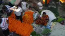 Para pedagang menjajakan bunga untuk dijual selama Festival Durga Puja di pinggir jalan Siliguri, India, Selasa (12/10/2021). Durga Puja juga disebut Durgotsab adalah festival tahunan di Asia Selatan untuk memuja dewi Durga dari agama Hindu. (DIPTENDU DUTTA/AFP)