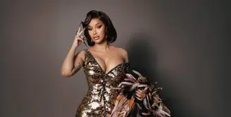 Rapper berbakat ini tampil memukau dalam gaun emas karya Roberto Cavalli yang menonjolkan siluet mermaid dengan korset yang mempertegas lekuk tubuhnya. [@iamcardib].