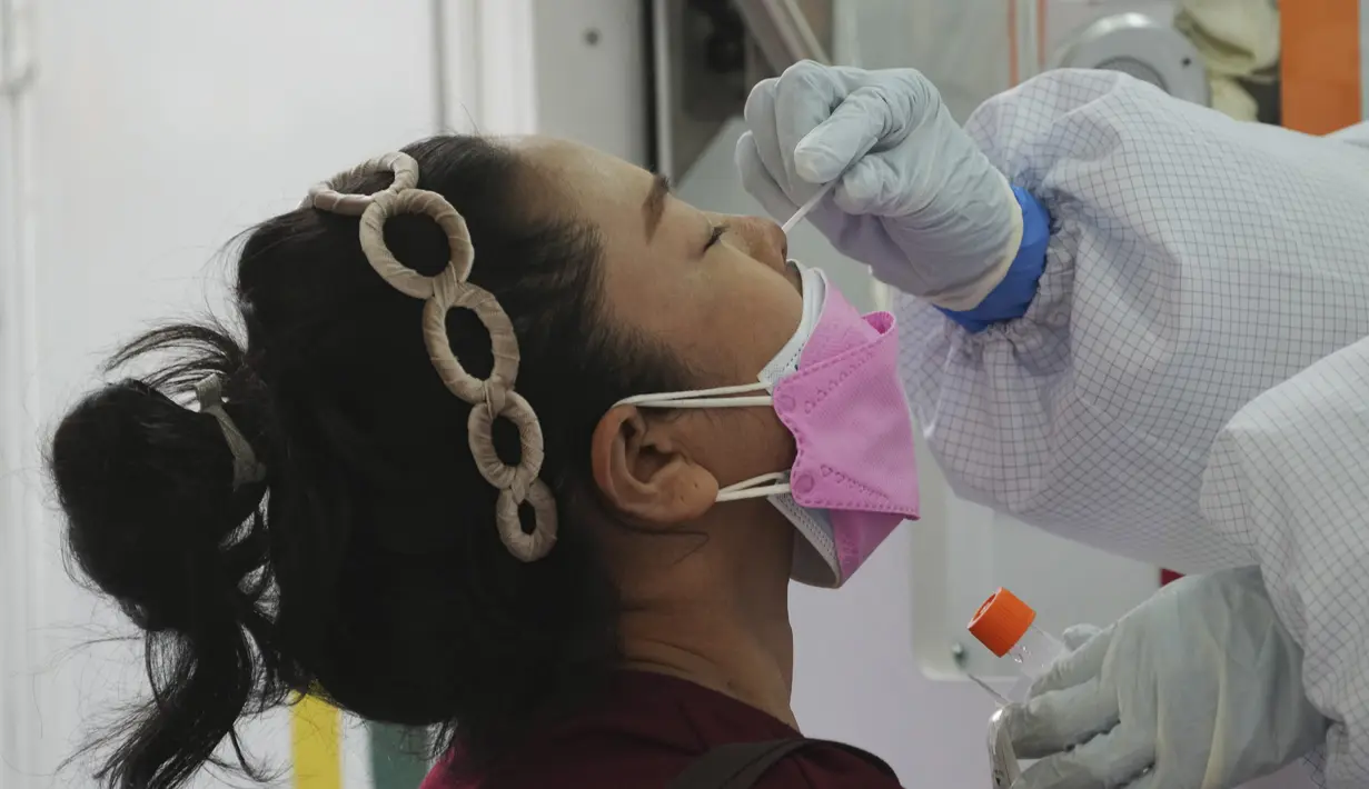 Seorang petugas kesehatan mengambil swab hidung seorang wanita untuk tes virus corona di sebuah pasar di Bangkok, Thailand, Jumat (11/6/2021). Thailand juga melaporkan 43 kematian baru akibat Covid-19 sehingga total kematian mencapai 1.375 orang sejak awal pandemi. (AP Photo/Sakchai Lalit)