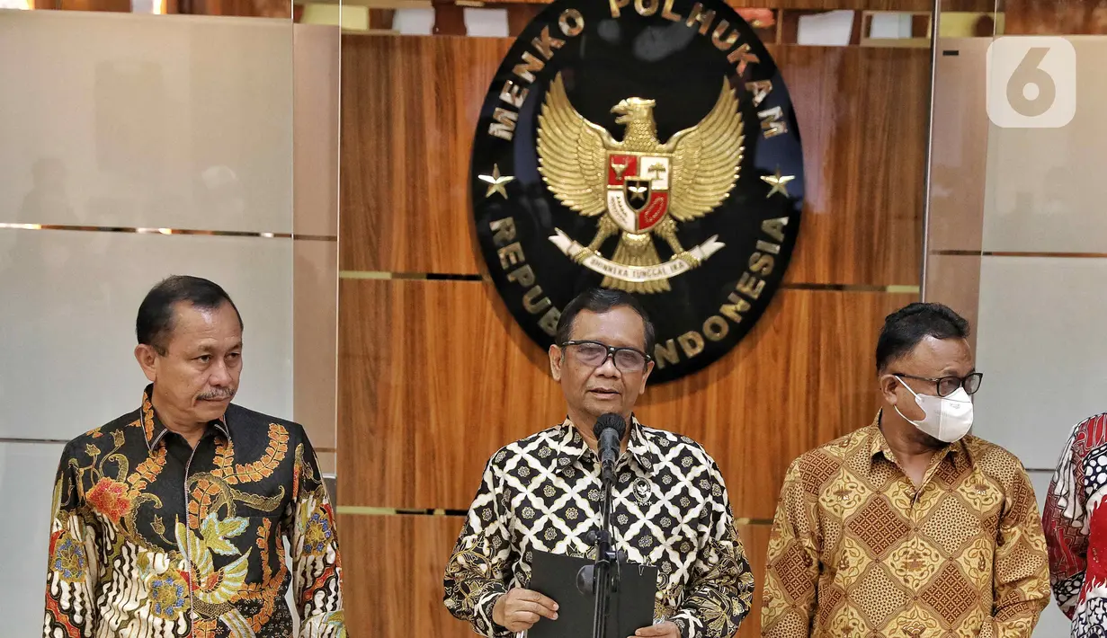 Menteri Koordinator Bidang Politik, Hukum, dan Keamanan (Menko Polhukam) Mahfud MD (tengah) bersama Ketua Komnas HAM Ahmad Taufan Damanik (kiri) menyampaikan keterangan di sela penyerahan berkas laporan terkait investigasi tragedi Kanjuruhan di Kantor Menko Polhukam, Jakarta, Kamis (3/11/2022). Menko Polhukam mewakili Presiden Joko Widodo atau Jokowi menerima laporan terkait investigasi tragedi Kanjuruhan yang berisi rekomendasi untuk membekukan seluruh kegiatan PSSI. (Liputan6.com/Angga Yuniar)