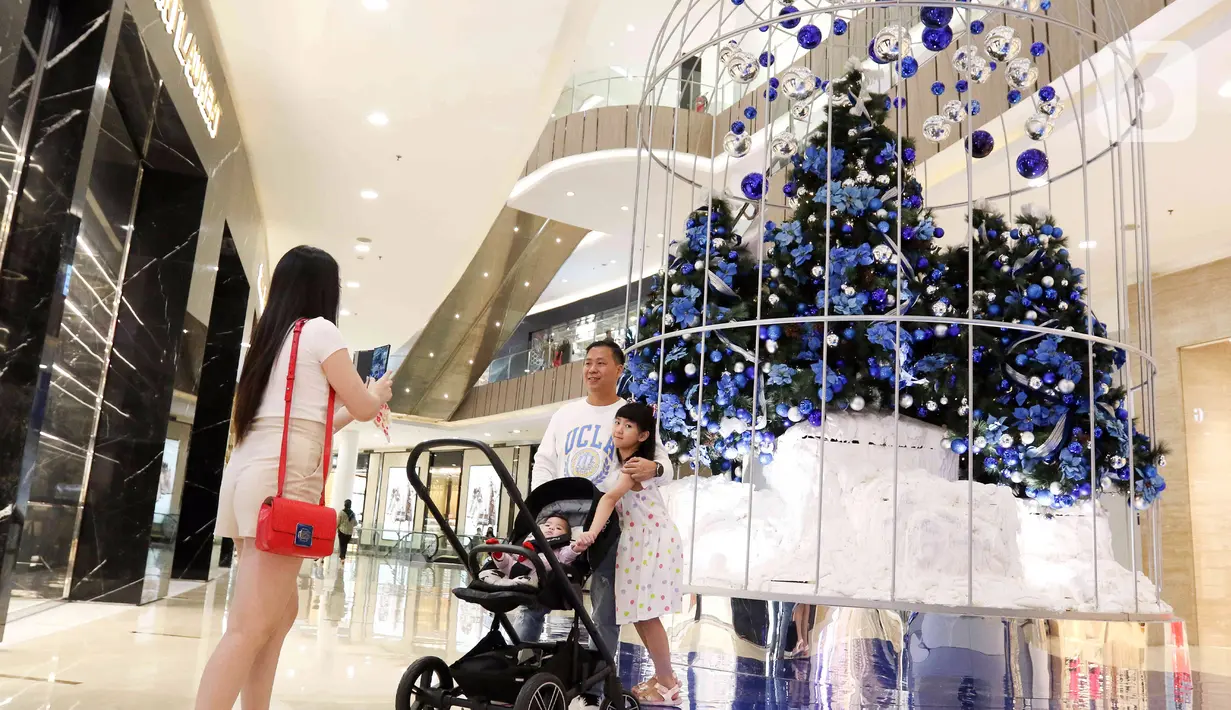 Seorang anak berpose di depan pohon Natal di Senayan City, Jakarta, Senin (14/12/2022). Senayan City menghadirkan Festive Season – The Festive Mood mulai tanggal 12 Desember – 8 Januari 2023, salah satunya Avatar Pandora Experience. (Liputan6.com/Herman Zakharia)