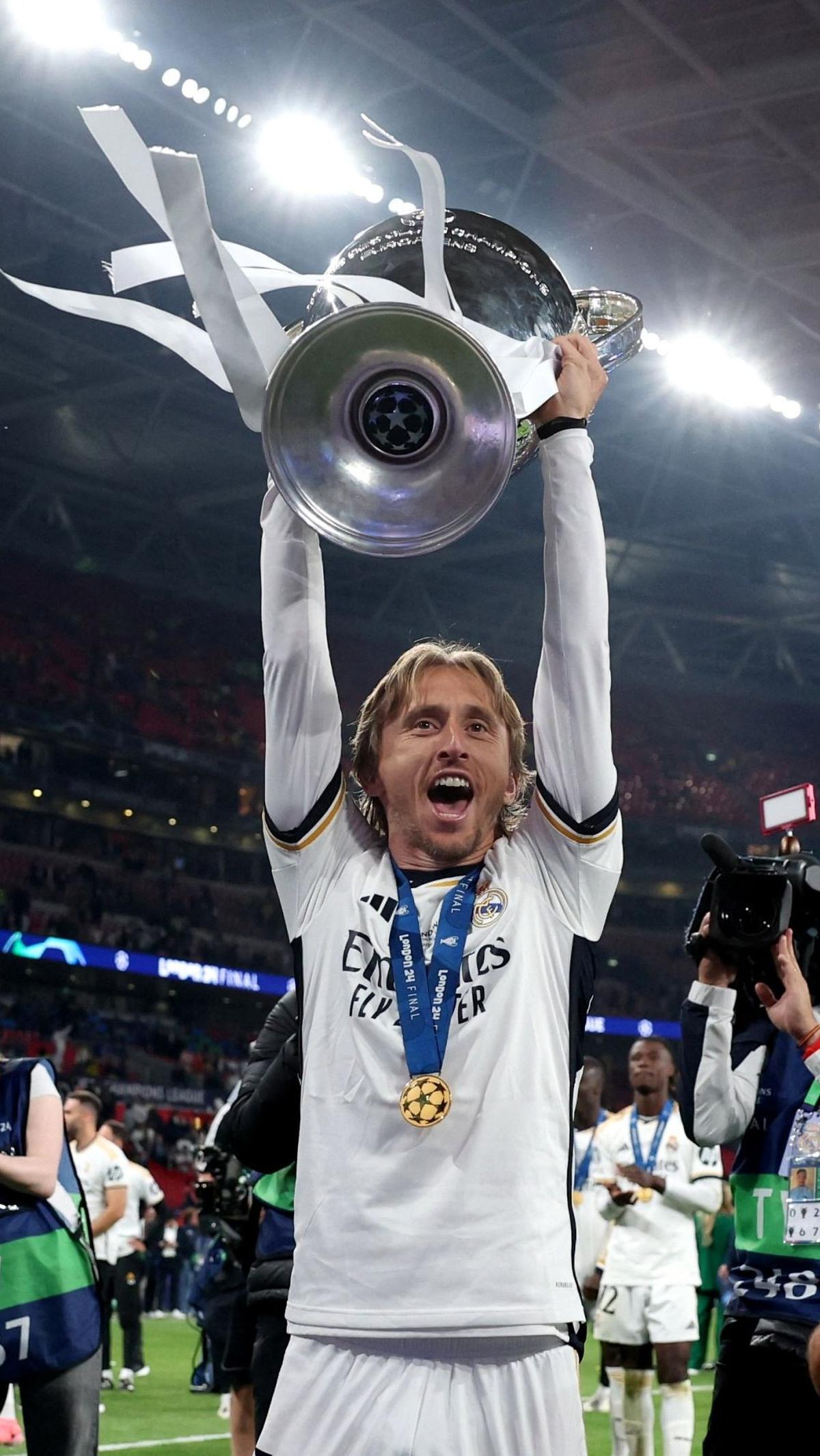 Luka Modric mengangkat trofi saat merayakan kemenangan di final Liga Champions. Foto: REUTERS